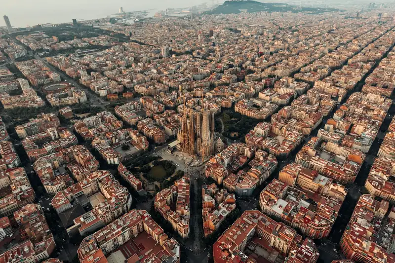 Luchtfoto van de wijk Eixample in Barcelona bij gouden licht, met de Sagrada Família in het midden