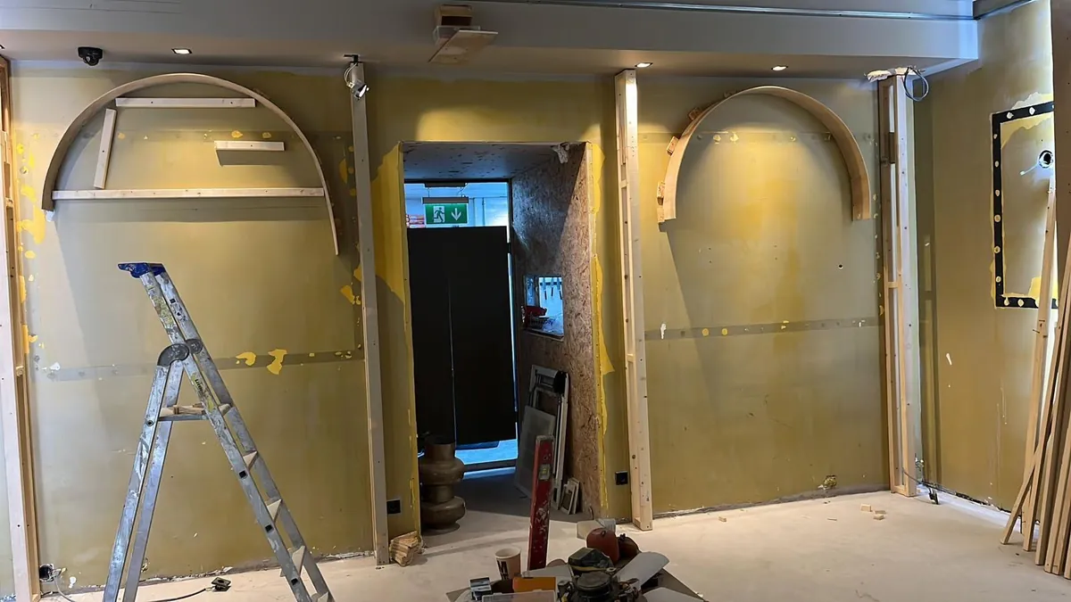 Estancia en obras con estructura de madera para dos hornacinas en arco