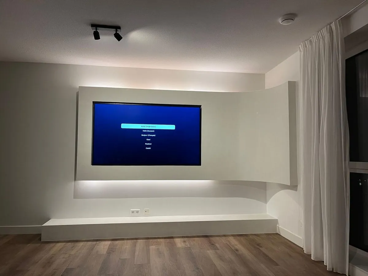 Pared curva blanca para el televisor, con iluminación indirecta